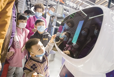 图为11月22日，观众在“互联网之光”博览会百度展厅与机器人“小度”人机对话。（图片来源：视觉中国）