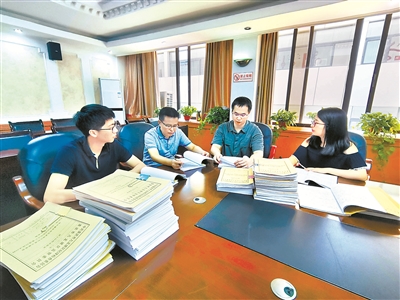 图为九龙坡区纪委监委案件审理室工作人员研究冯海军案定性相关证据。 向导 摄
