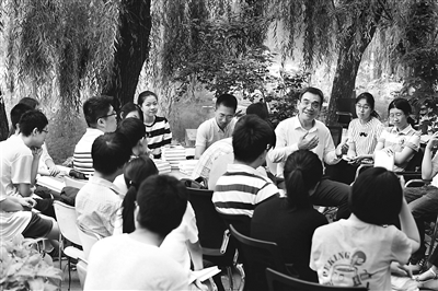 图为林毅夫与北京大学学生在北大校园交流探讨。资料图片