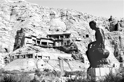 克孜尔石窟外景。克孜尔石窟是龟兹文化的一颗明珠。石窟前陈列的塑像是龟兹译经大师鸠摩罗什，他曾到长安主持译经。 （资料图片）