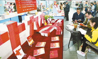 十一月五日,读者在新疆乌鲁木齐市新华国际图书城党的十九大读物展台前翻阅选购十九大学习辅导读物。