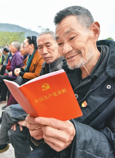 重庆市丰都县虎威镇红岩村7社,老党员李明友在十九大精神院坝宣讲会上认真学习新《党章》。