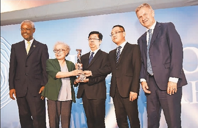 图为老、中、青3位塞罕坝人陈彦娴(左二)、刘海莹(中)、于士涛(右二)与联合国环境规划署执行主任埃里克·索尔海姆(右一)在颁奖台上合影。 新华社记者 陈 诚摄