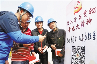 安徽省合肥市瑶海区建筑施工现场,基层党务工作者向流动党员送上新党章和十九大学习读物,并指导他们扫描“十九大微课堂”二维码,通过手机及时学习十九大精神。 解 琛摄(人民视觉)