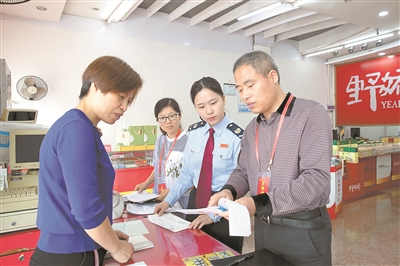 图为“五一”期间,浙江省淳安县纪委监委联合税务部门对当地土特产店进行检查,核对销售台账和相关票据清单。毛勇锋 摄