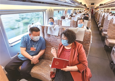 5月20日,出席十三届全国人大三次会议和全国政协十三届三次会议的河北省代表委员赴京报到。这是代表们在车厢里讨论关心关注的热点话题。赵威 摄