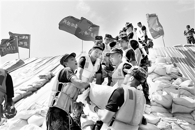 今年入汛以来,我国部分地区遭受严重洪涝灾害。在党中央坚强领导下,广大党员干部和人民子弟兵舍生忘死,在抗洪抢险中始终冲锋在前。图为武警江西总队赣州支队官兵在九江彭泽县芙蓉墩圩堤搬运沙袋加固堤坝。 新华社记者 洪水平 摄