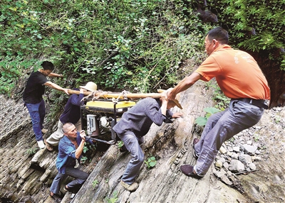重庆市巫山县两坪乡溪沟村长期季节性缺水,为切实解决缺水难题,村干部带领群众上山寻水。图为2020年6月,该村干部群众抬着百余斤重的发电机穿越陡峭的悬崖,把海拔800多米高的山泉水引到村上蓄水池。苏耀波 摄