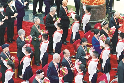 6月29日,庆祝中国共产党成立100周年“七一勋章”颁授仪式在北京人民大会堂金色大厅隆重举行。图为少先队员向勋章获得者献花,敬礼致意。新华社记者 高洁 摄