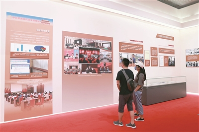 为庆祝中国共产党成立100周年,2021年7月8日,“让党中央放心、让人民群众满意——新时代中央和国家机关党的建设成就巡礼展”在国家博物馆开幕。展览中全面从严治党相关内容备受关注。图为观众观看中央和国家机关举报网站展板。 (图片来源:人民视觉)