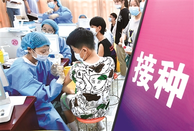 图为近日,在安徽省阜阳市阜师大体育中心方舱新冠疫苗接种点,医护人员为12至17岁的初、高中学生接种新冠疫苗。 (图片来源:视觉中国)
