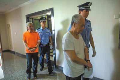 饶道群(右)和李军被带向法庭