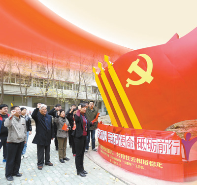 10月19日,新疆维吾尔自治区乌鲁木齐市碱泉东社区党支部组织党员群众在社区七彩党建主题文化园学习十九大报告。图为社区组织党员重温入党誓词。