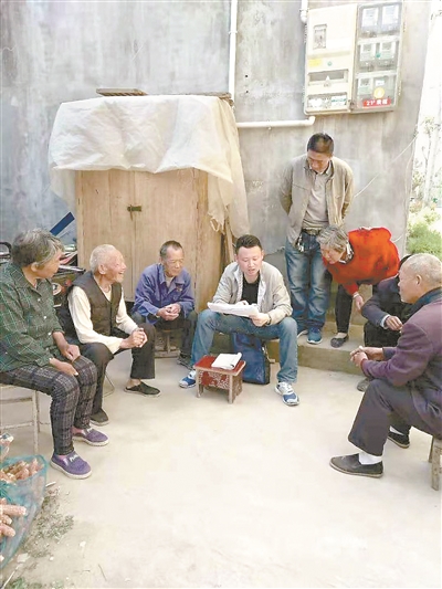 图为颜亮亮(左四)向群众宣讲政策,听取意见。(资料图片)