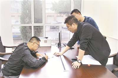 图为李昊(左一)在谈话笔录上签字。 尹兆书 摄