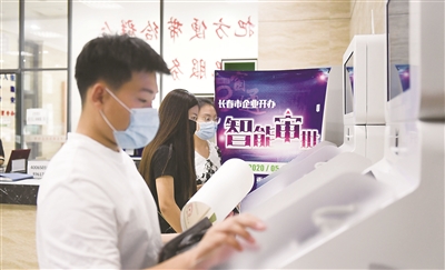 长春市企业开办智能审批系统自5月18日上线以来,通过智能化审批新设立599户市场主体,其中企业313户,个体工商户286户。该系统代替传统人工审批模式,实现企业开办登记全程零见面、零跑动、零干预。图为市民在长春市朝阳区政务大厅内的企业开办智能审批一体机上办理业务。新华社记者 颜麟蕴 摄