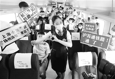 7月1日,沪苏通铁路开通运营,缩短了上海与南通以及苏北地区的时空距离,有力助推长三角一体化发展。图为当日,首趟列车C3836次动车乘务员在车厢内为旅客表演节目。 新华社记者 陈飞 摄