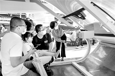 图为在第三届数字中国建设峰会期间,福耀集团展区展出的最新的车载智能投屏玻璃吸引不少观众。图为几名观众在工作人员讲解下现场体验。 魏影 摄