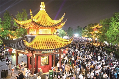 许多景区引导游客夜间旅游,通过时间的延展扩大景区的容量。图为“五一”假期期间,游客在南京夫子庙景区赏秦淮夜景,乐享假日时光。(图片来源:视觉中国)