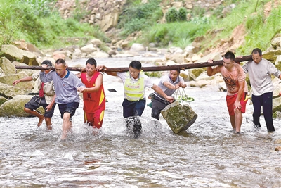 在位于黔桂交界大苗山深处的乌英苗寨,驻村第一书记韦桂华(右四)、党员梁成兵(右三)、梁志新(左二)带领村民维修河堤。新华社记者 黄孝邦 摄