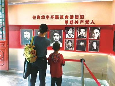 家长带着小朋友正在学习革命历史。 本报记者 曹溢 摄
