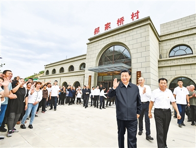 9月13日至14日,中共中央总书记、国家主席、中央军委主席习近平在陕西省榆林市考察。这是14日下午,习近平在绥德县张家砭镇郝家桥村考察时,向乡亲们挥手致意。新华社记者 谢环驰 摄