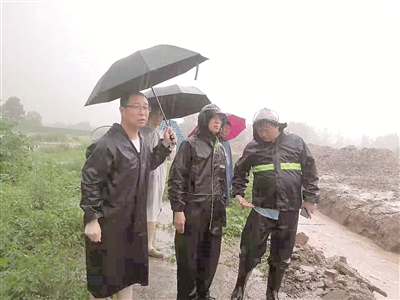 连日来,河南省郑州市遭遇持续强降雨,严重汛情给人民群众生命财产安全造成重大威胁。全市纪检监察干部闻“汛”而动,积极投身防汛救灾一线。图为该市纪委监委第二监督检查室干部在管城区王垌村察看防汛排水情况,督导疏排积水、加固大堤。(郑州市纪委监委供图)