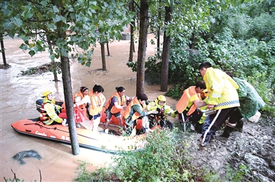 7月20日,受持续强降雨影响,河南省郑州市单日降雨量突破历史极值,单小时降雨量超过日历史极值,严重威胁群众生命财产安全。图为当日,消防救援人员在该市唐庄镇龙头村转移被困村民。新华社记者 郝源 摄