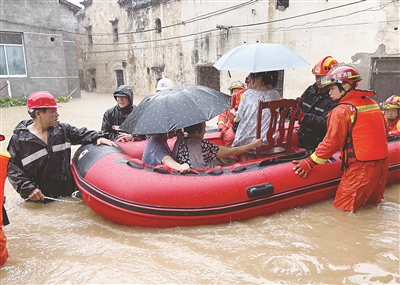 台风“烟花”带来的短时强降雨使诸暨市次坞镇新徐坞杨村低洼区严重积水。图为该镇纪检监察干部会同消防人员转移受灾群众。 骆涵泽 摄