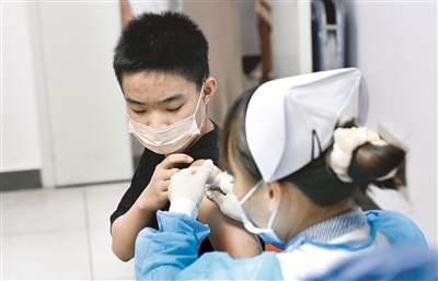 近日,海南省海口市加快推进12至17周岁人群新冠疫苗接种工作。图为8月4日,在海口市人民医院新冠病毒疫苗接种点,医护人员在为接种者接种疫苗。 新华社记者 杨冠宇 摄