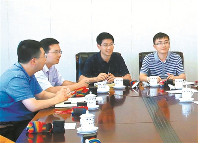 图为赵钟伟(右二)在和委机关青年同志进行学习交流。(资料图片)