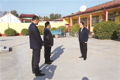 图为关鲁(右一)深入村庄走访调研,向干部群众了解有关情况。(齐河县纪委监委供图)