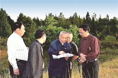 图为周永开(中)在花萼山调研植被保护。(达州市纪委监委供图)
