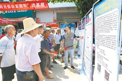江西省宜黄县纪委监委把惩治基层“微腐败”同扫黑除恶专项斗争结合起来,严查黑恶势力背后的“保护伞”。图为近日该县纪检监察干部向群众讲解涉黑涉恶典型案例和举报公告。 李明珠 摄