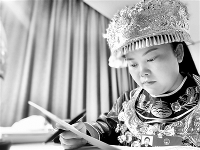 图为杨芳在湖北代表团驻地整理议案建议。