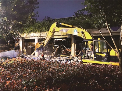 7月26日夜,南京市相关部门组织对违建的门窗、装修设施、砖砌墙体等进行拆除。为避免可能对秦淮河大堤造成沉降、位移等影响,建筑的混凝土框架暂时保留。图为拆除现场。刘建雄 摄