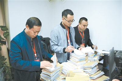 图为利州区纪委监委调查人员在核对案件相关账册。刘玥 摄