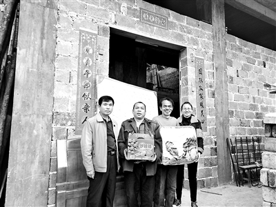 图为覃杵华(右二)乔迁新居当天,甘坚(右一)为其送去床、被子和水果等物资。