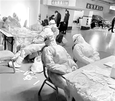 图为医护人员在石家庄槐底社区开展核酸检测,他们在工作间隙稍作休息。胡一刀 摄