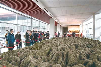 图为游客在井冈山革命博物馆参观,听解说员讲解井冈山斗争地形图。正是在这样崎岖蜿蜒的山地环境中,井冈山革命根据地不断扩大,点燃了工农武装割据的星星之火,为中国革命探索出农村包围城市、武装夺取政权的正确道路。(图片来源:视觉中国)